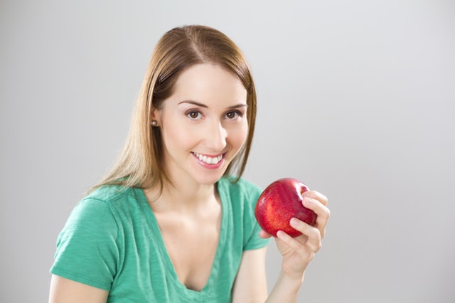 žena s jablkem v ruce